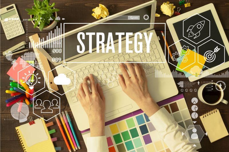 An image of a person working on a laptop to develop a marketing strategy.